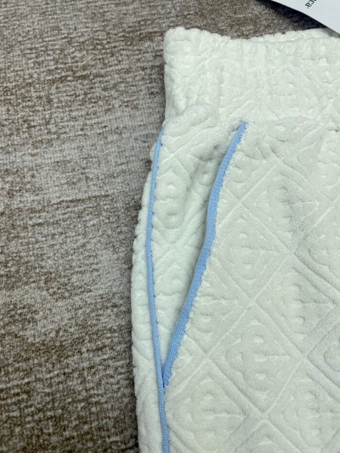 Pantaloni casual bianco con dettagli in blu e tessuto morbido e testurizzato.