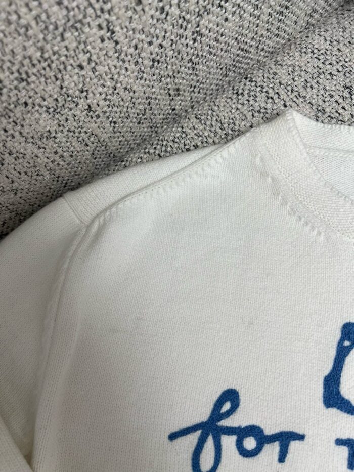 Maglione bianco casual con scritta blu, morbido e ideale per il relax quotidiano.