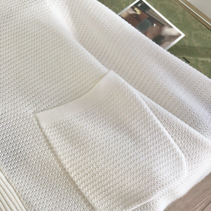 Vestito bianco con tasca, tessuto morbido e texture elegante per uno stile casual e confortevole.