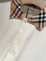 Polo beige con colletto Burberry check, stile elegante e dettagli raffinati.
