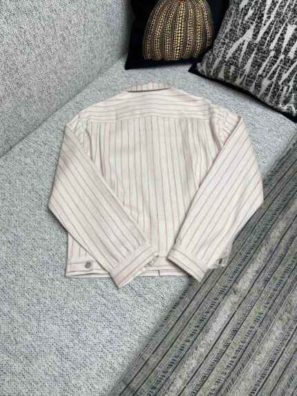Giacca casual a righe colorate su divano elegante, stile e comfort in casa.