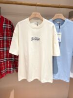 Abbigliamento casual con t-shirt “Eternal”, flanella rossa e t-shirt azzurra in boutique elegante.
