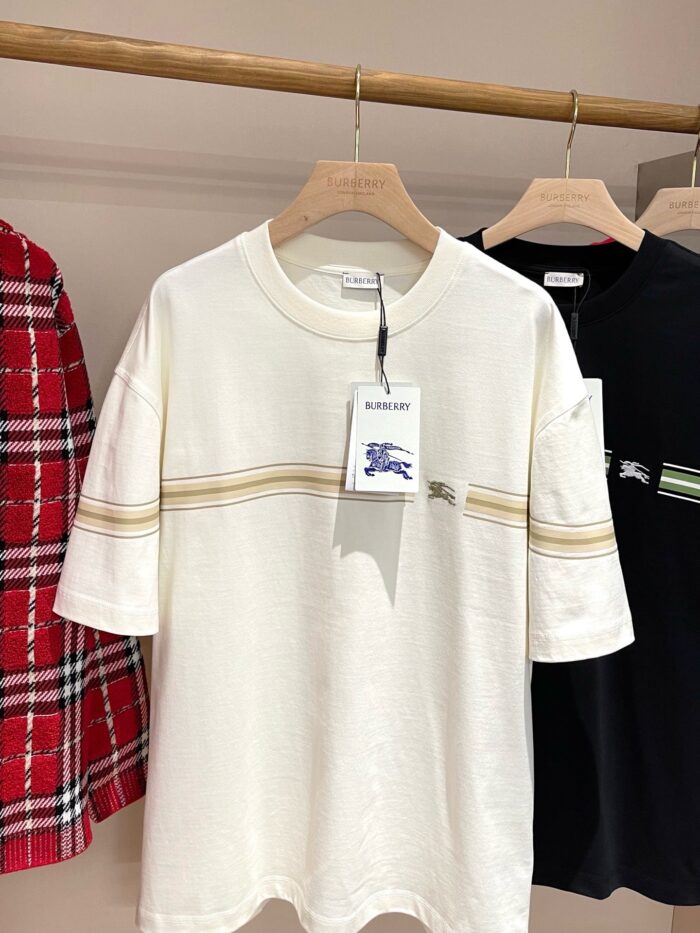 T-shirt casual neutro con strisce dorate, stile rilassato e elegante.