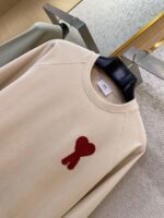 Felpa beige con patch a cuore rosso, stile casual e trendy, perfetta per ogni outfit.