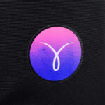 Logo circolare con gradiente rosa e blu su sfondo nero opaco, design moderno e minimalista.