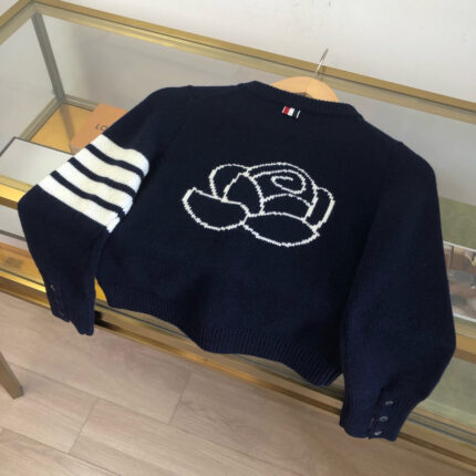 Maglione cropped navy con ricamo di rosa bianca e dettagli a righe sulle maniche.