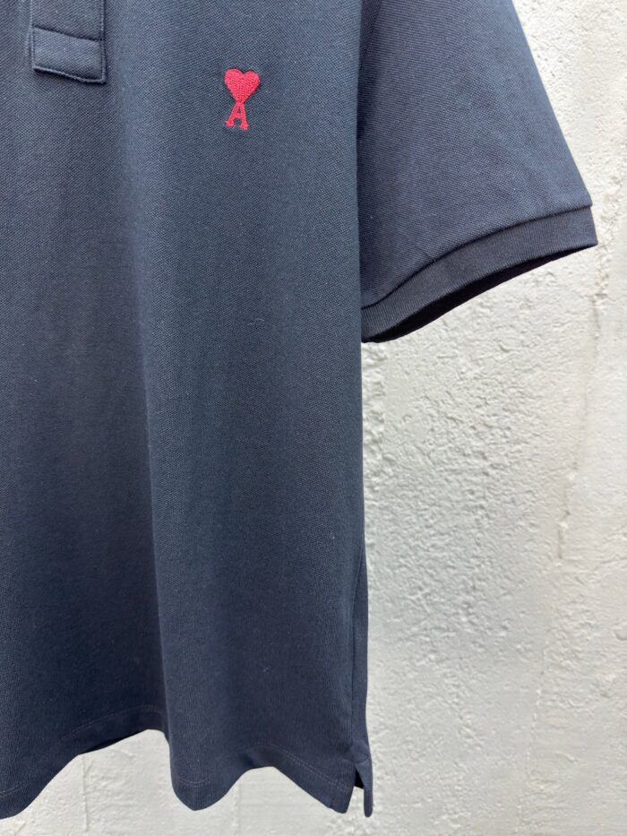 Polo navy con logo cuore rosso, dettagli moderni, tessuto morbido e taglio elegante.