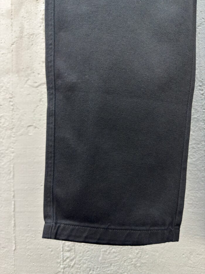 Dettaglio dellorlo dei pantaloni neri, cucitura precisa, tessuto elegante e vestibilità versatile.