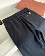 Pantaloni neri comodi con elastico, tasca posteriore e stile casual o semi-formale.