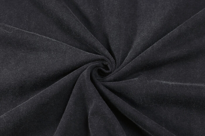 Tessuto nero velour in spirale, texture liscia, brillante ed elegante per moda e arredamento.