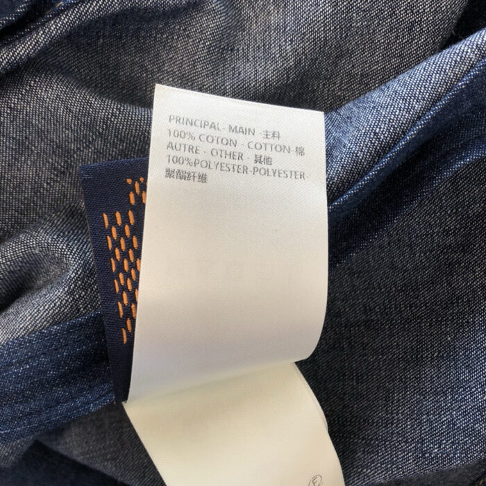Etichetta in cotone e poliestere su denim di alta qualità, dettagli tessuti e composizione.