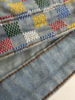 Denim colorato con ricami a diamante, dettagli ricamati e tessuto resistente.