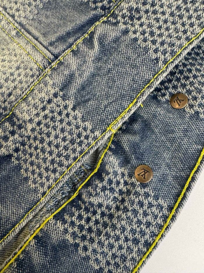 Jeans con motivo a quadri, cuciture gialle e bottoni in metallo brunito.