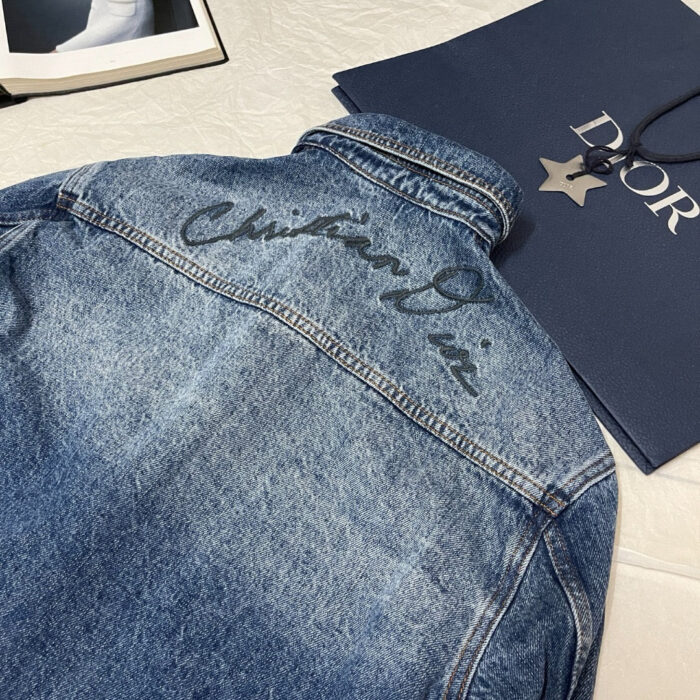 Giacca jeans Dior ricamata e moderna, con borsa di lusso, stile elegante e casual.