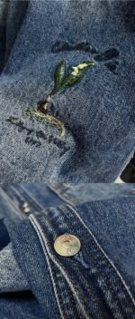 Dettaglio di ricamo di pianta verde su denim con bottone metallico, stile eco-friendly e vintage.