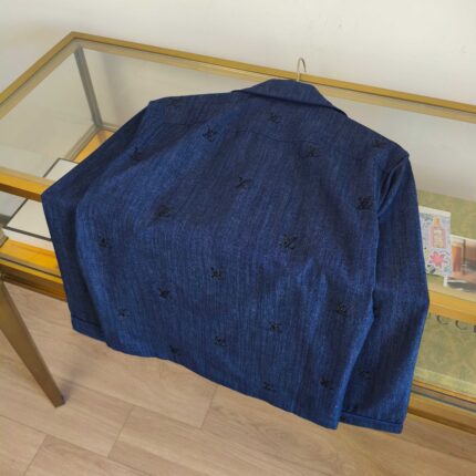 Giacca jeans ricamata elegante su tavolo in vetro, stile moderno e originale.