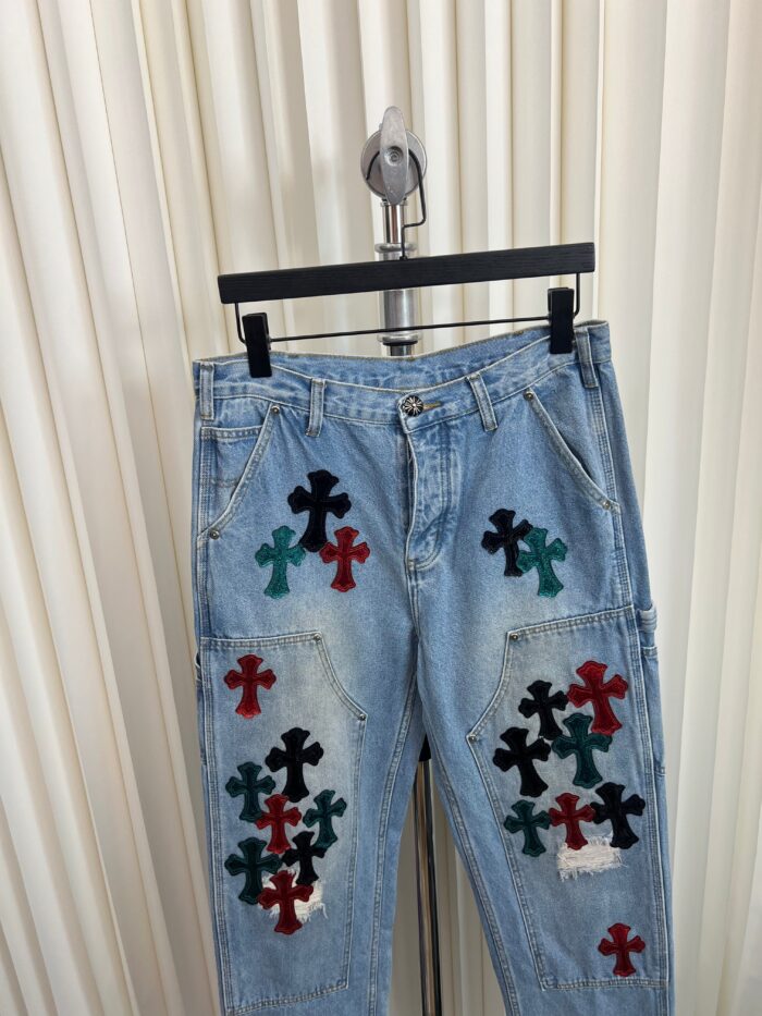 Jeans chiari con croci colorate artistiche su rastrelliera, stile casual e creativo.