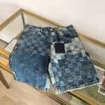 Shorts in jeans patchwork con tasche e taglio rilassato su tavolo di vetro.