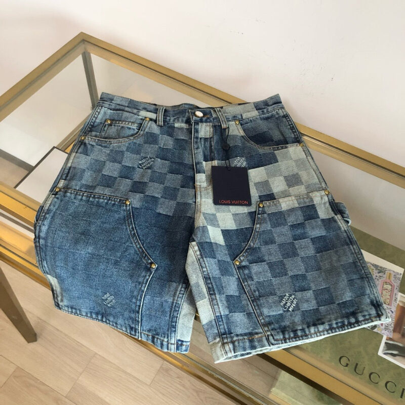 Shorts in jeans patchwork con tasche e taglio rilassato su tavolo di vetro.