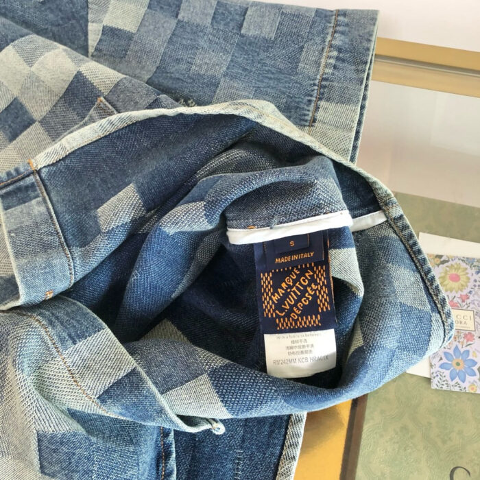 Giacca in denim patchwork con interno checkered e etichetta di design distintivo.