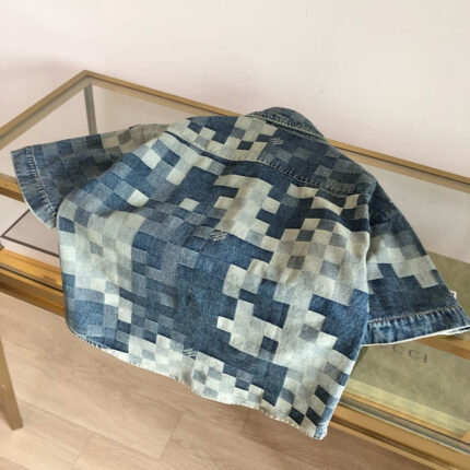 Giacca in denim pixelata moderna su tavolo di vetro, stile creativo e casual.