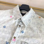 Camicia in denim ricamata di lusso con patch colorati e dettagli eleganti.