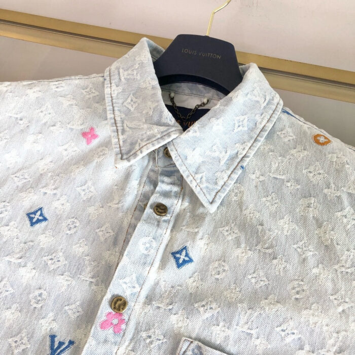 Camicia in denim ricamata di lusso con patch colorati e dettagli eleganti.
