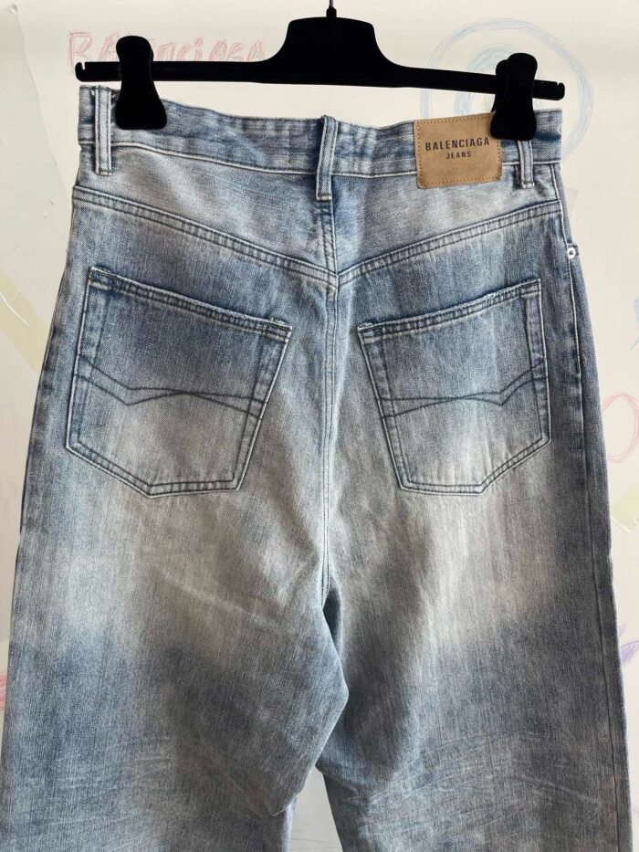 Jeans vintage blu con tasche posteriori ampie, effetto usato e dettagli in primo piano.