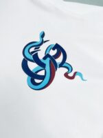 T-shirt con design astratto, linee fluide e colori vivaci, stile moderno e artistico.