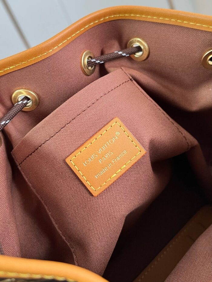 Interno di una borsa di design con tessuto beige, dettagli in metallo e etichetta elegante.