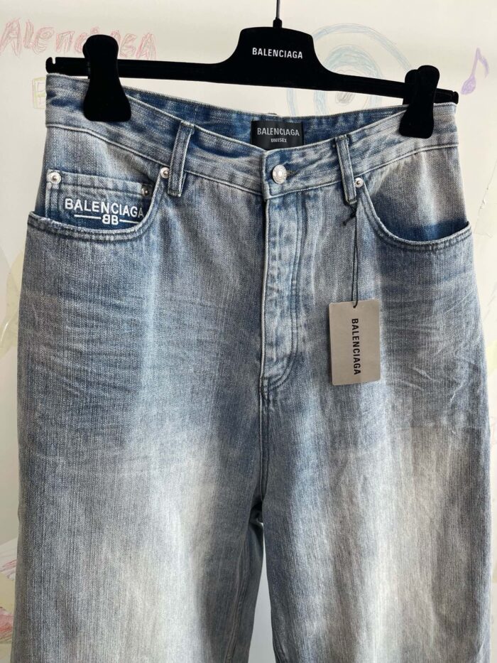 Jeans Balenciaga a vita alta in denim faded blue, stile vintage e moderno, eleganti e di lusso.
