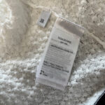 Etichetta di lusso Thom Browne in tessuto cotone elastan, dettagli eleganti e qualità premium.