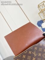 Borsa di lusso in pelle con monogramma, fodera arancione contrastante e design elegante.