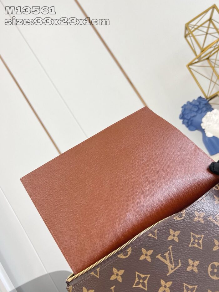 Borsa di lusso in pelle con monogramma, fodera arancione contrastante e design elegante.