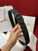 Cintura Dior nera elegante, con scatole di lusso e dettagli raffinati.