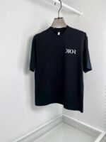 Maglietta nera Dior minimalista in cotone con logo bianco, stile elegante e sofisticato.