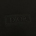Logo Dior ricamato su tessuto nero opaco di lusso, raffinato e minimalista.