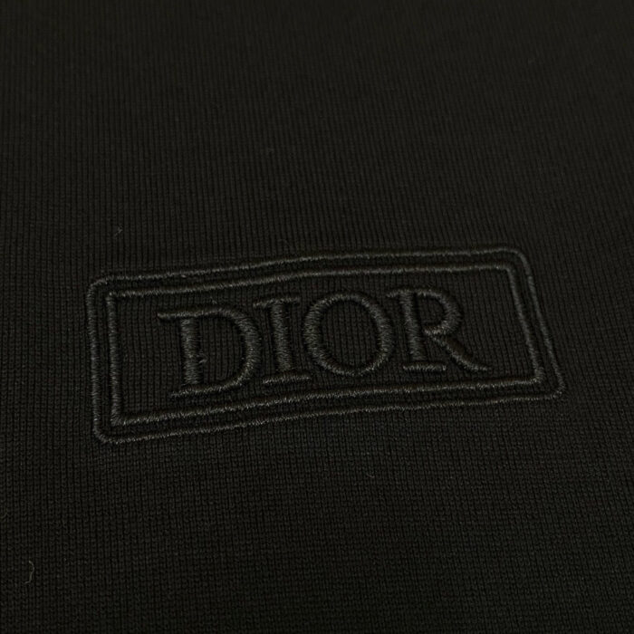Logo Dior ricamato su tessuto nero opaco di lusso, raffinato e minimalista.