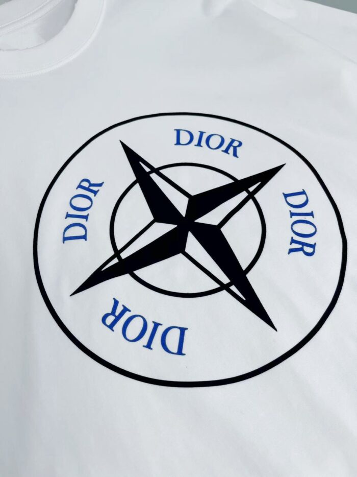 T-shirt Dior bianca con simbolo a bussola, stella e dettagli blu eleganti.