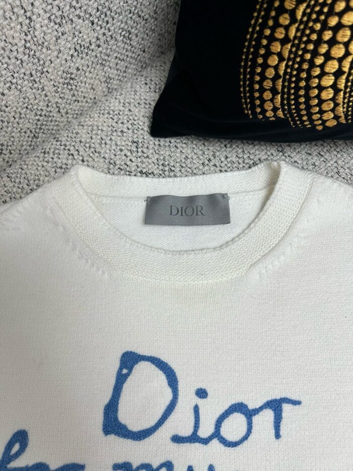 Maglione Dior in maglia avorio con dettagli artistici e logo blu elegante.