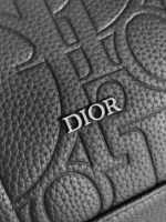 Pelle nera Dior con logo in metallo e dettagli embossati, simbolo di lusso e raffinatezza.