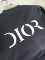Maglietta nera Dior con logo bianco, moda elegante e di lusso.