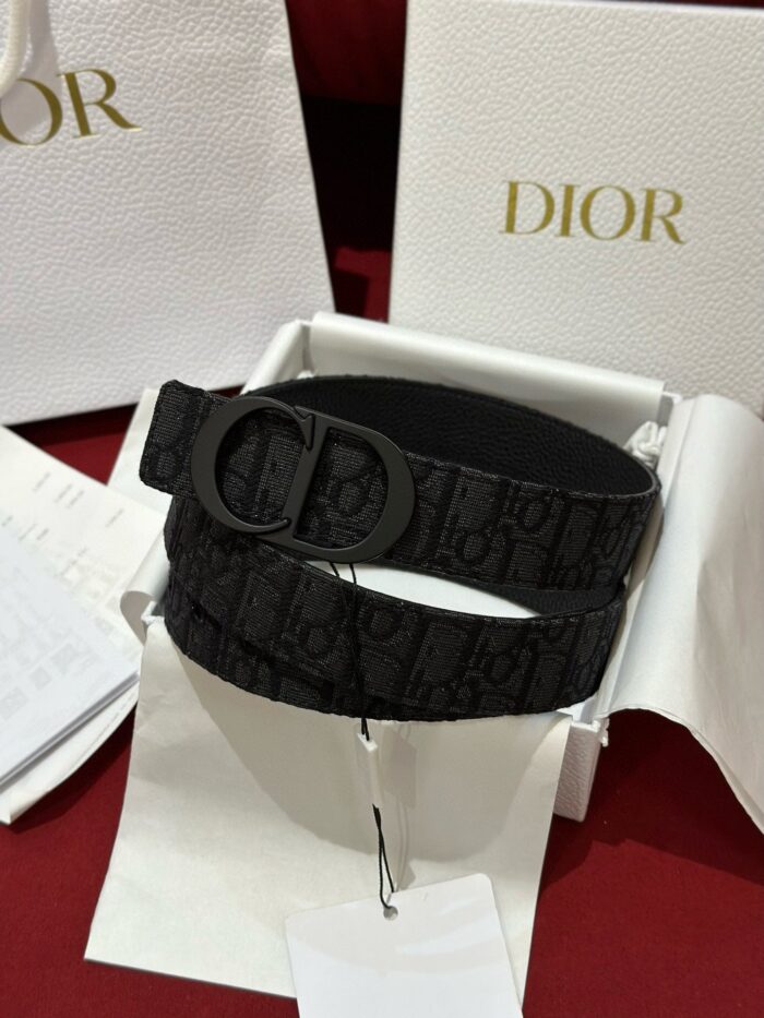 Cintura Dior nera con fibbia elegante, confezione di lusso e sfondo rosso raffinato.