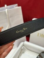 Accessorio Dior in pelle nera di lusso con logo dorato e stile elegante.