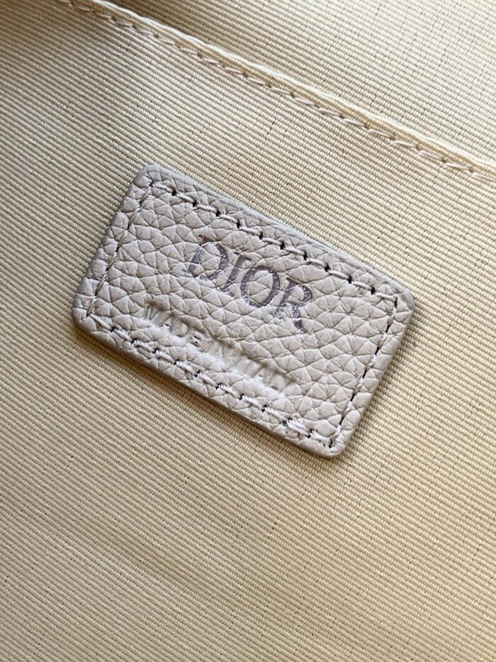 Etichetta Dior in pelle di lusso con cuciture e logo embossato elegante.