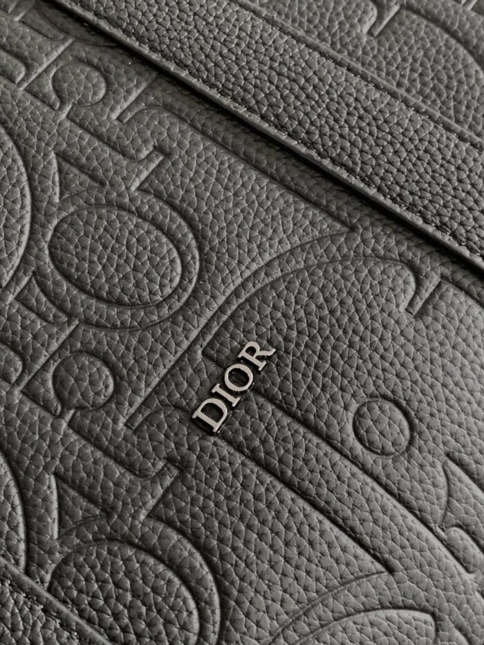 Texture in pelle Dior con logo metallico, dettagli artigianali e design elegante di lusso.