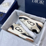 Sneakers Dior eleganti in scatola blu con dettagli crema, nero e tortora, stile lusso e raffinatezza.