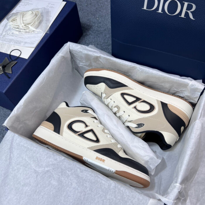 Sneakers Dior eleganti in scatola blu con dettagli crema, nero e tortora, stile lusso e raffinatezza.
