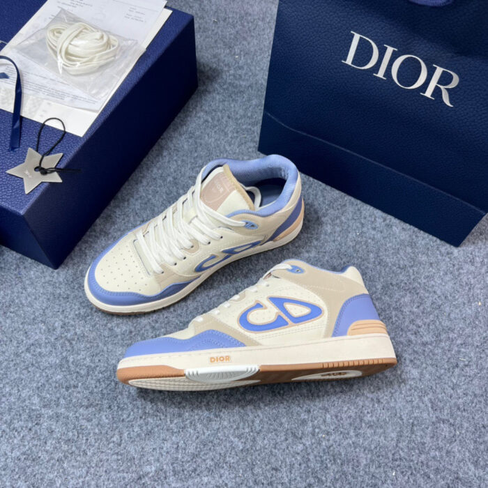 Sneakers Dior casual in crema e azzurro con borsa navy e occhielli aperti, stile elegante e moderno.