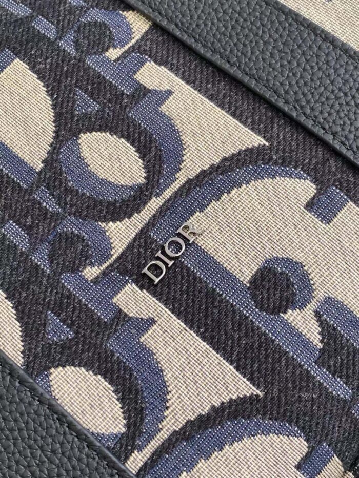 Tessuto Dior di lusso con motivo stilizzato, logo metallizzato e bordo verde raffinato.